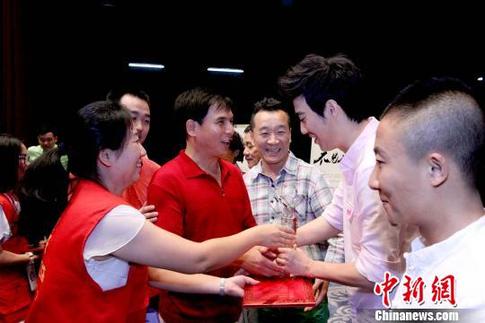 志愿者为爱心演员颁发奖杯和证书。 张道正 摄