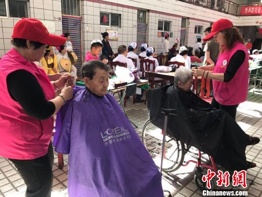 志愿者们为老人梳理头发。 迪娜 摄