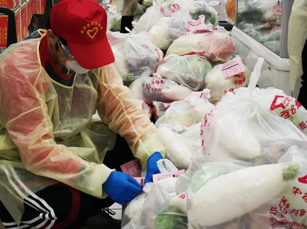 2020年,武汉青年志愿者在中百仓储百步亭花园路店开展新冠疫情防控